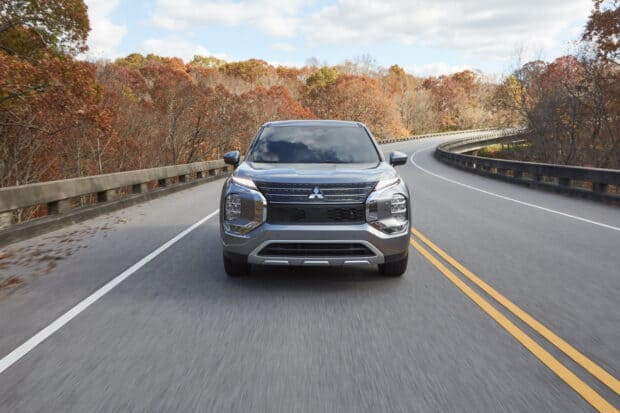 A Mitsubishi Outlander is driving on a curved road surrounded by autumn trees, HD Desktop Wallpaper