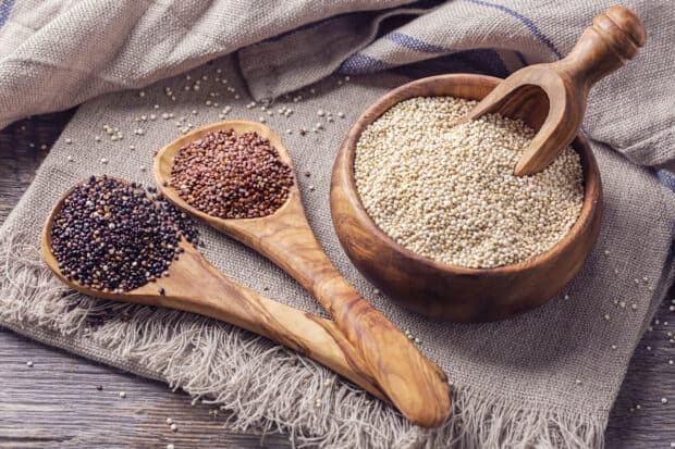 A close up of quinoa seeds displayed in wooden spoons and a bowl on a rustic cloth, HD Desktop Wallpaper