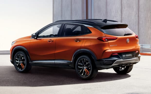 A modern Buick Encore with a sleek orange side profile is shown against a concrete wall, HD Desktop Wallpaper