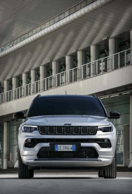 A silver Jeep Grand Cherokee is parked under a large architectural canopy, 2K Mobile Wallpaper