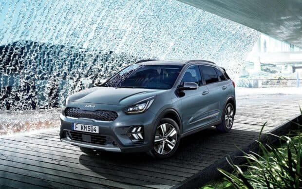 A modern Kia SUV parked near a dynamic water fountain feature in an urban setting, HD Desktop Wallpaper