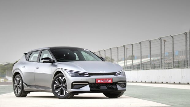 The silver Kia car is parked on a race track near a fence, HD Desktop Wallpaper