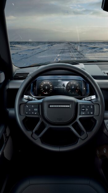 The Land Rover Defender dashboard shows the steering wheel and digital gauges on a snowy road, 4K Mobile Wallpaper