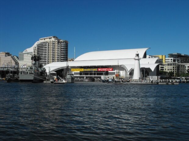 The Maritime Museum is located by the waterfront with a lighthouse and docked ships, 2K Desktop Wallpaper