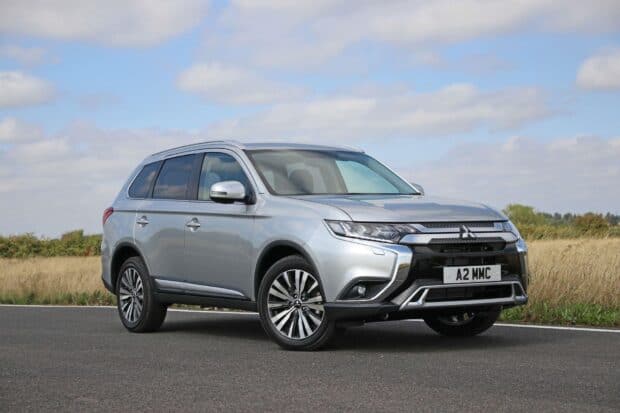 A silver Mitsubishi Outlander is parked on the road under a cloudy sky, HD Desktop Wallpaper