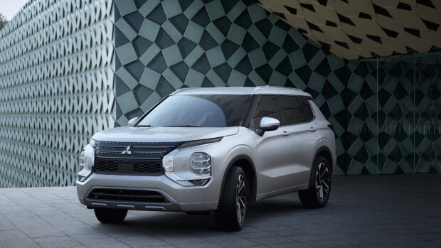 A silver Mitsubishi Outlander is parked near a patterned architectural wall under soft lighting, 4K Desktop Wallpaper
