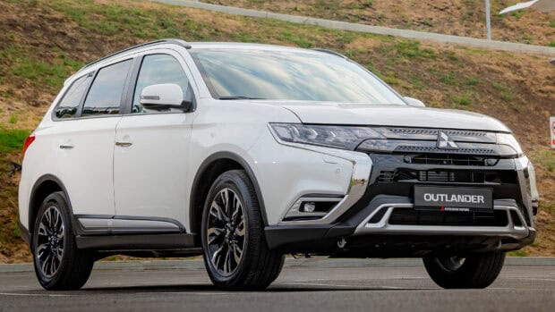 A white Mitsubishi Outlander is parked on a paved road with a grassy background, HD Desktop Wallpaper