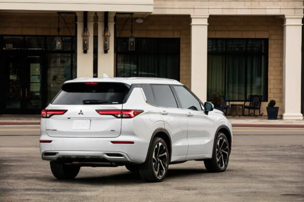 A white Mitsubishi Outlander is parked on the street in front of a building in this Mitsubishi Outlander Wallpapers photo, HD Desktop Wallpaper