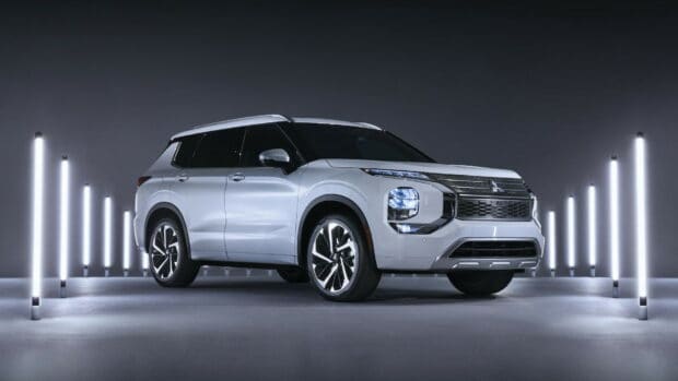 A white Mitsubishi Outlander is showcased with bright vertical lights in a dark setting, HD Desktop Wallpaper