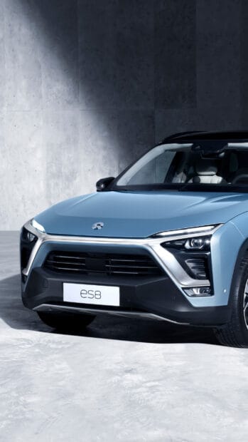 The image shows a blue Nio Auto es8 model against a concrete background, 2K Phone Wallpaper