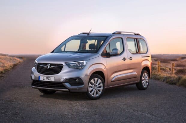 A modern Opel Combo is parked on a road at sunset with a natural landscape in the background, 2K Desktop Wallpaper