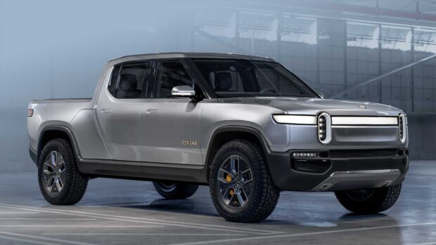 A silver Rivian electric truck stands inside a spacious industrial warehouse with a clean concrete floor, HD Desktop Wallpaper