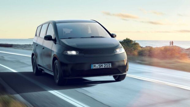 A black Sono Motors van moves along a coastal highway with ocean views, HD Desktop Wallpaper