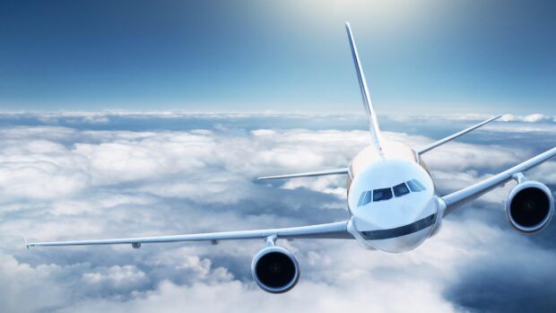 A modern aircraft is captured flying high above the clouds on a clear day, 4K Desktop Wallpaper