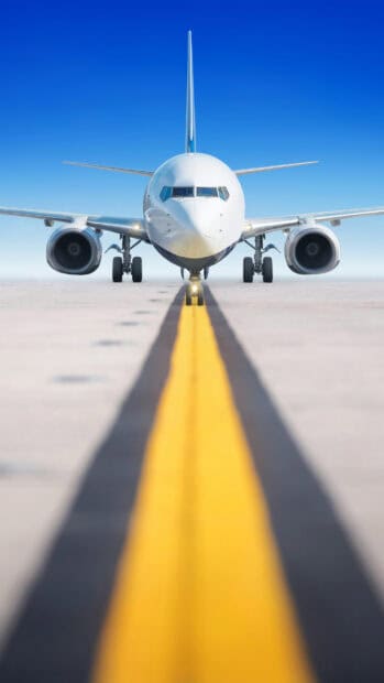 An aircraft is positioned on the runway with clear blue sky in the background, 2K Phone Wallpaper