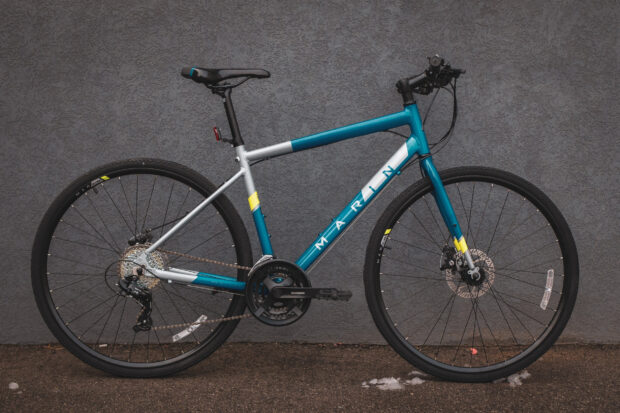 A modern blue and silver Marin bike is parked against a gray textured wall, HD Desktop Wallpaper