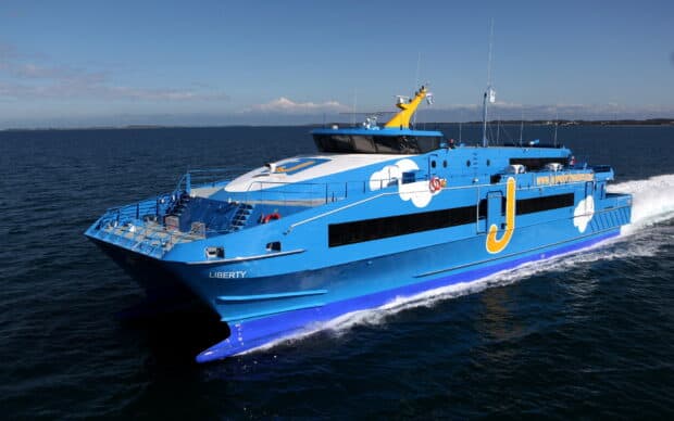 A blue ferry named Liberty is cruising across calm ocean waters with clear skies, HD Desktop Wallpaper