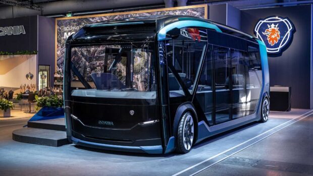 A modern electric Scania bus is displayed in a showroom with sleek design and glass panels, HD Desktop Wallpaper