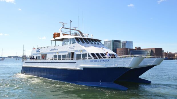 A modern ferry named Nathaniel Bowditch sails through a calm harbor with city buildings in the background, 4K Desktop Wallpaper