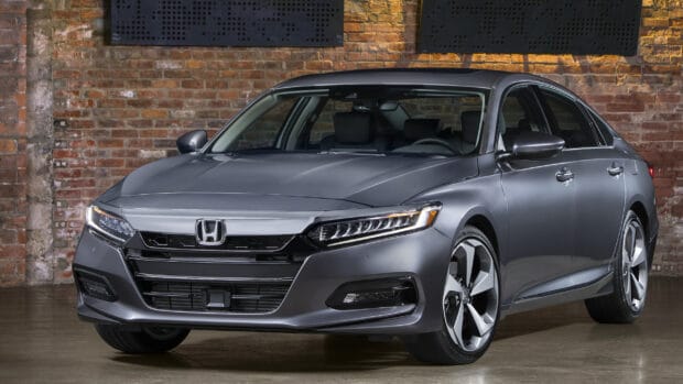 A gray Honda Accord is parked indoors against a brick wall showing its front and side profile, 2K Desktop Wallpaper