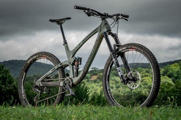 A modern transition bike stands on the grassy hill with hills and cloudy sky in the background, HD Desktop Wallpaper