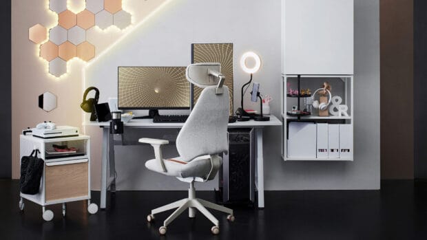 A modern office desk setup includes a gray ergonomic chair and a computer displaying abstract designs as Ikea Wallpapers, HD Desktop Wallpaper