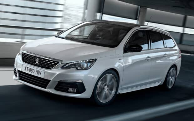 A white Peugeot 308 is moving swiftly through a modern cityscape, showing its sporty design, HD Desktop Wallpaper