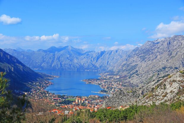 A beautiful view of Montenegro with the bay and surrounding mountains under a blue sky, HD Desktop Wallpaper