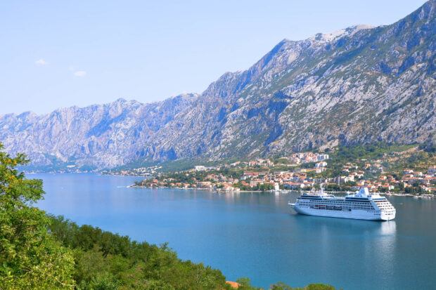 A cruise ship sails along the beautiful coastline of Montenegro with mountains in the background, 2K Desktop Wallpaper