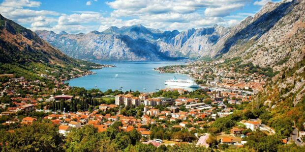 A scenic view of Montenegro with a coastal town and surrounding mountains, HD Desktop Wallpaper