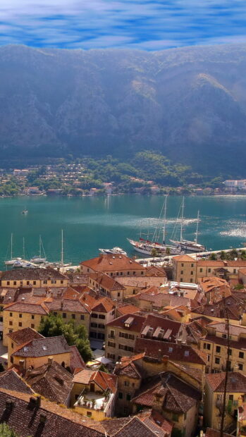 A scenic view of a Montenegro town with red rooftops by the water, HD Mobile Wallpaper