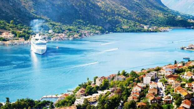 The Montenegro coastline shows a cruise ship near a coastal town surrounded by green mountains, 4K Desktop Wallpaper