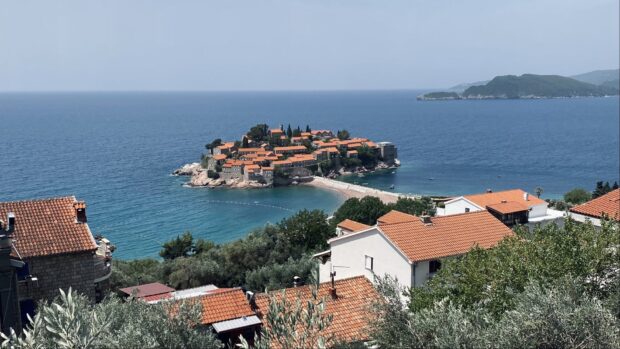 A scenic view of Montenegro with a coastal village and the Adriatic Sea under a clear sky, HD Desktop Wallpaper
