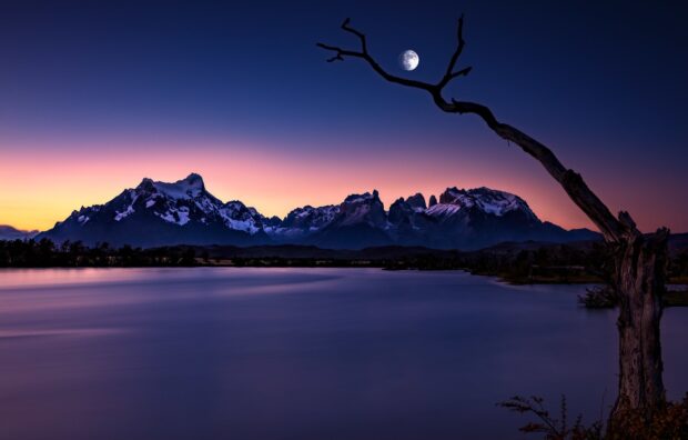 A calm lake reflects the Torres Del Paine National Park mountains under a moonlit sky, HD Desktop Wallpaper