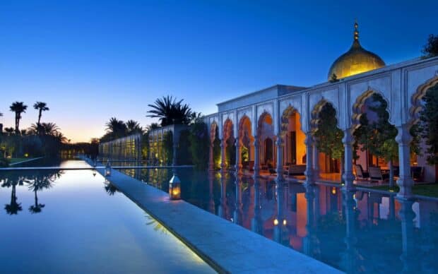A peaceful view of Morocco with a mosque reflected in the calm water at sunset, HD Desktop Wallpaper