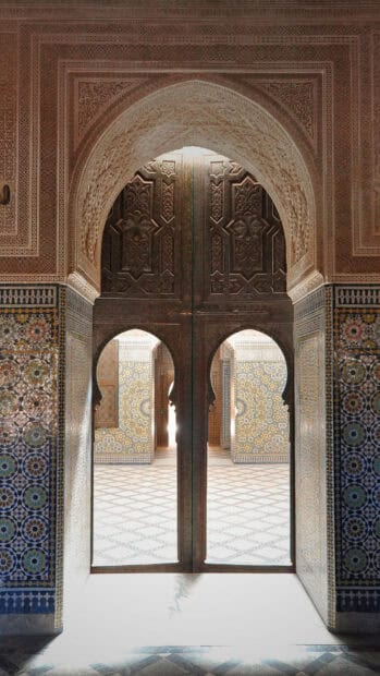 A detailed view of an ornate Morocco archway with mosaic patterns and carved wooden door, HD Phone Wallpaper