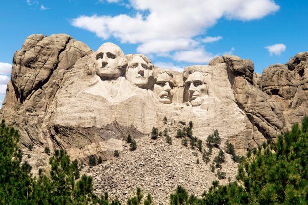 The Mount Rushmore monument features carved faces of four U.S. presidents against a blue sky, 2K Desktop Wallpaper
