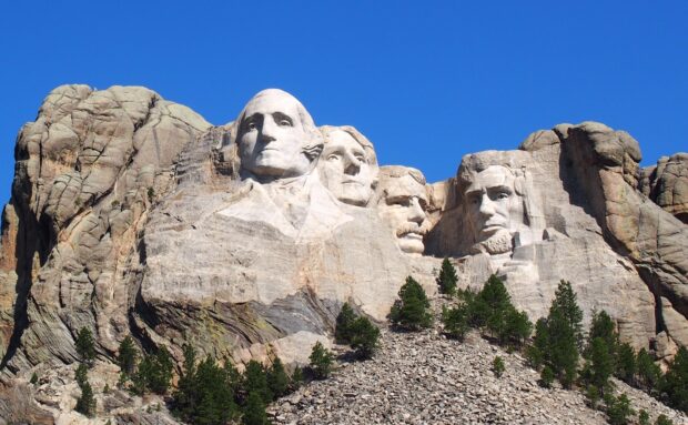 The Mount Rushmore national monument features the carved faces of four U.S. presidents under a bright blue sky, 2K Desktop Wallpaper