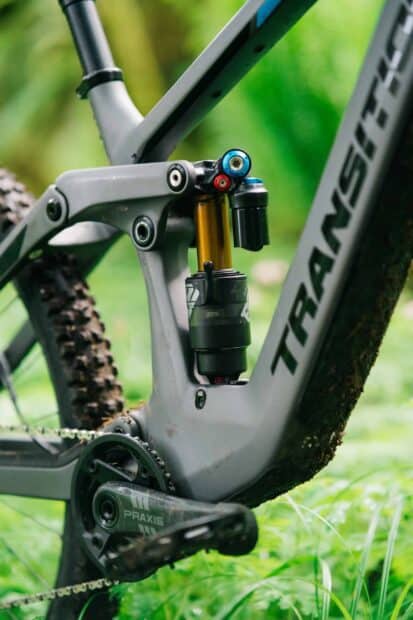 A close up view of mountain bike suspension on a gray Transition Bikes frame in nature, 2K Mobile Wallpaper