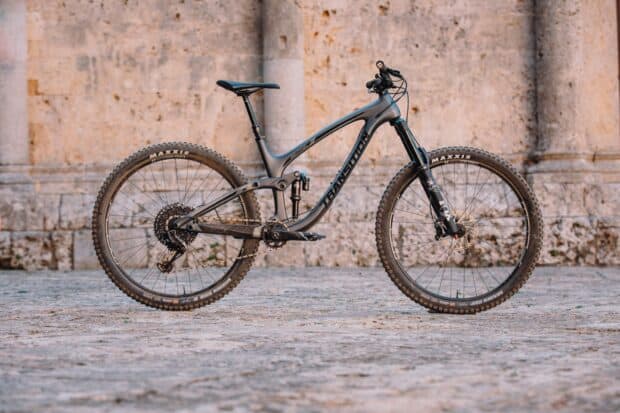 A Transition bike stands on a stone surface beside a textured wall, HD Desktop Wallpaper