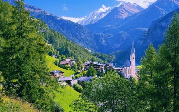 The village wallpapers show a peaceful mountain village with green trees and a church steeple, HD Desktop Wallpaper