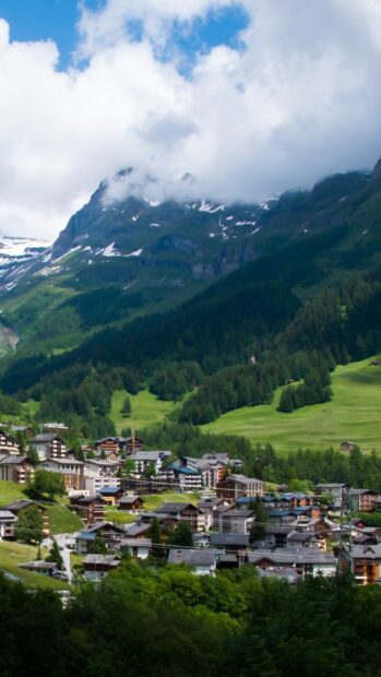 A village surrounded by lush greenery and snowy mountains under a cloudy sky showing village wallpapers, HD Phone Wallpaper