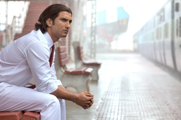 A man in a white outfit sits thoughtfully on a bench in a train station, HD Desktop Wallpaper