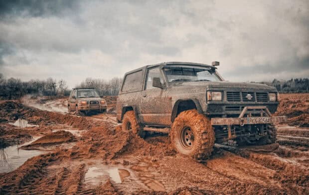 Two off road driving vehicles are struggling through muddy terrain, HD Desktop Wallpaper