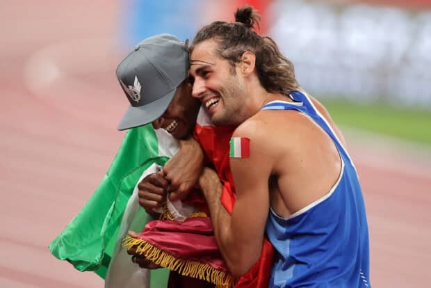 Mutaz Essa Barshim smiling while embracing a fellow athlete wrapped in a flag, HD Desktop Wallpaper