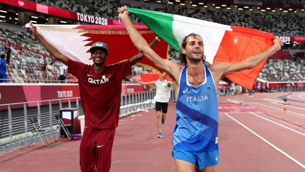Mutaz Essa Barshim celebrates victory while holding a flag on the Olympic track, 2K Desktop Wallpaper