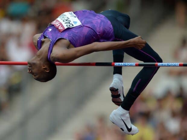 Mutaz Essa Barshim clears the bar in a high jump competition during a track event, HD Desktop Wallpaper