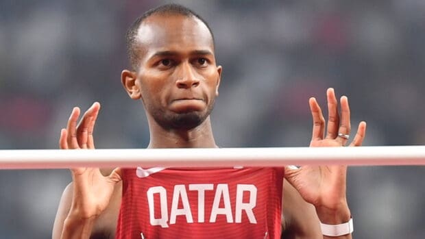 Mutaz Essa Barshim is concentrating during a high jump event wearing Qatar uniform, 4K Desktop Wallpaper