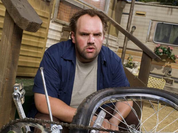 A man is fixing a bicycle wheel in an outdoor setting from My Name Is Earl TV series, HD Desktop Wallpaper