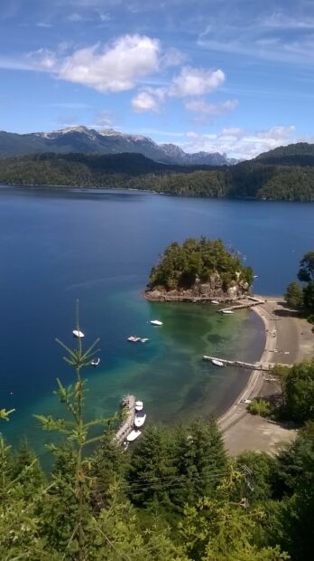 A peaceful view of Nahuel Huapi with clear water and surrounding forests, 2K Mobile Wallpaper